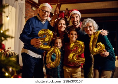 Portrait of happy extended family with 2024 balloons during New Year celebration at home looking at camera.  - Powered by Shutterstock