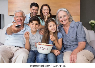 Portrait of happy extended family watching tv on sofa in the living room at home - Powered by Shutterstock