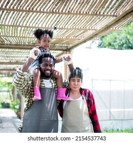 Portrait Of Happy Family African  Village Couple With Their Baby Girl. Happy African American Child Girl With Family At Farm