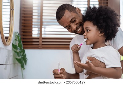 Portrait of happy family black African American father son child boy brushing teeth in bathroom. Morning routine with toothbrushes, father’s day. Brushing teeth, kid boy with dental hygiene toddler - Powered by Shutterstock