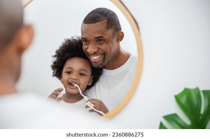 Portrait of happy family black African American father son child boy brushing teeth in bathroom. Morning routine with toothbrushes, father’s day. Brushing teeth, kid boy with dental hygiene toddler - Powered by Shutterstock