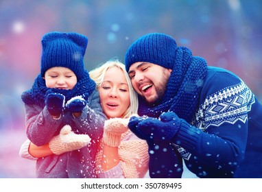 Portrait Of Happy Family Blowing Winter Snow