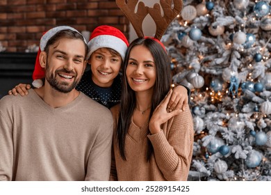 Portrait of happy family celebrating Christmas together at home. Parents and son kid child hugging embracing looking at the camera. Happy New Year Eve! - Powered by Shutterstock