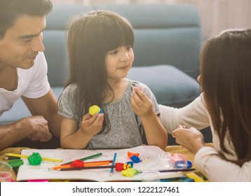 Portrait Of Happy Family Daughter Girl Is Learning To Use Colorful Play Dough Together With Parent