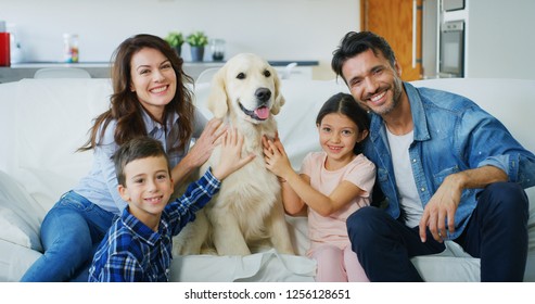 Portrait Of Happy Family With A Dog Having Fun Together In Living Room. Concept Of Happy Family, Love For Animals, Childhood
