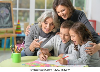 Portrait Of Happy Family Drawing Together At Home