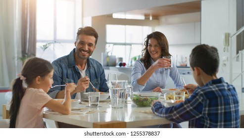 Portrait of happy family having lunch in dining room. Concept of healthy food, wellbeing, happy family - Powered by Shutterstock