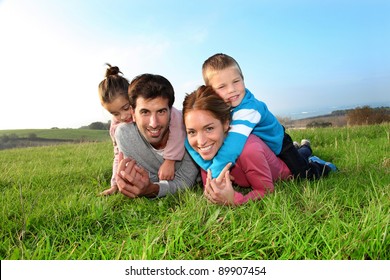 Portrait of happy family laying in country field - Powered by Shutterstock