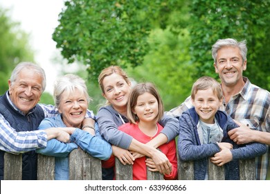Portrait of happy family leaning on fence