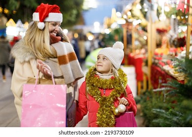 Portrait Of Happy Family Of Mother And Preteen Girl Looking Happy With Bags While Shopping On Christmas Street Fair