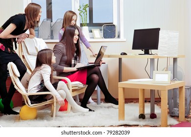 Portrait of happy family of only girls of different ages. They are looking at laptop display together