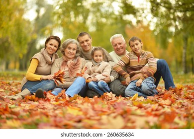 Portrait of happy family relaxing in autumn forest