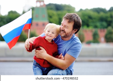 Portrait Of Happy Family With Russian Flag With Moscow Kremlin On Background