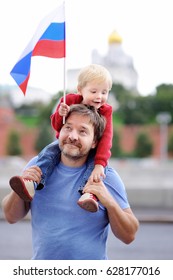 Portrait Of Happy Family With Russian Flag With Moscow Kremlin On Background