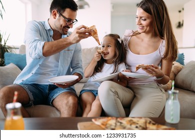 Portrait Of Happy Family Sharing Pizza At Home