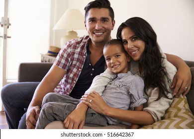 Portrait Of Happy Family Sitting On Sofa In at Home