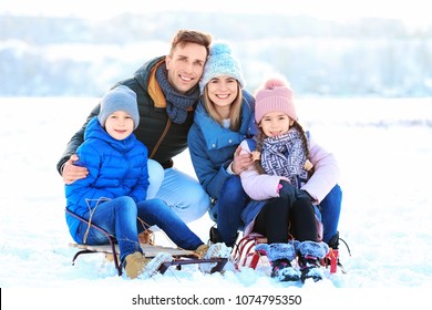 Portrait Of Happy Family With Sledge Outdoors On Winter Day