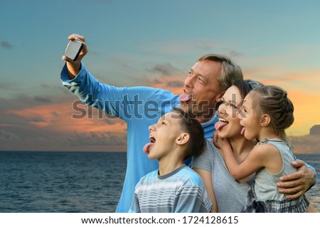 Portrait of happy family taking selfie on the sea beach