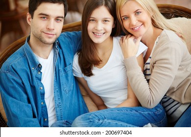 Portrait Of Happy Family Of Three Looking At Camera With Smiles