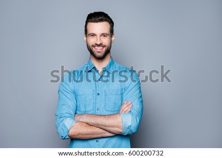 Portrait of happy fashionable handsome man in jeans shirt  crossing hands and look at camera
