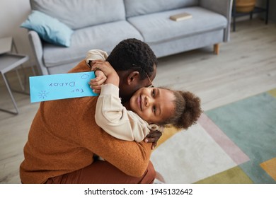 Portrait Of Happy Father Embracing Little Girl After Coming Home From Work On Fathers Day, Copy Space