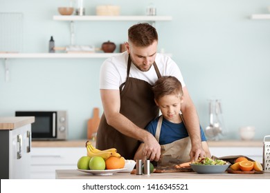 Portrait Of Happy Father And Son Cooking In Kitchen