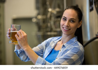 Portrait of happy female brewer testing beer at brewery - Powered by Shutterstock