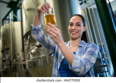 Portrait of happy female brewer testing beer at brewery - Powered by Shutterstock