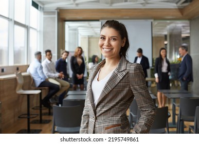 Portrait of happy female business teacher and professional coach. Beautiful young woman in jacket standing in office after corporate training class for team of employees, looking at camera and