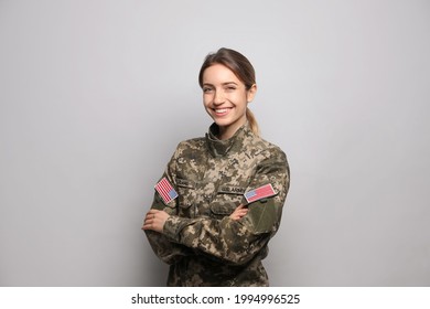 Portrait Of Happy Female Cadet On Light Grey Background