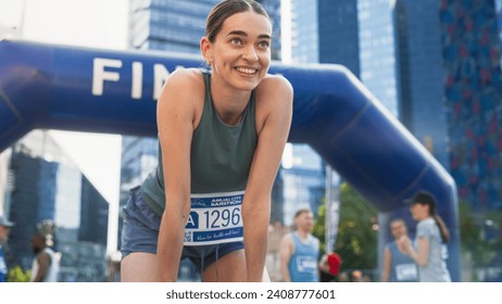 Portrait of a Happy Female City Marathon Runner Crossing the Finish Line and Celebrating her Victory. Female Race Winner Achieving her Goal and Enjoys her Accomplishement - Powered by Shutterstock