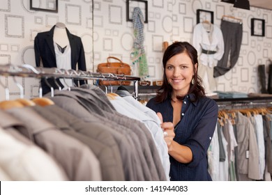 Portrait of happy female customer choosing shirt in clothing store - Powered by Shutterstock