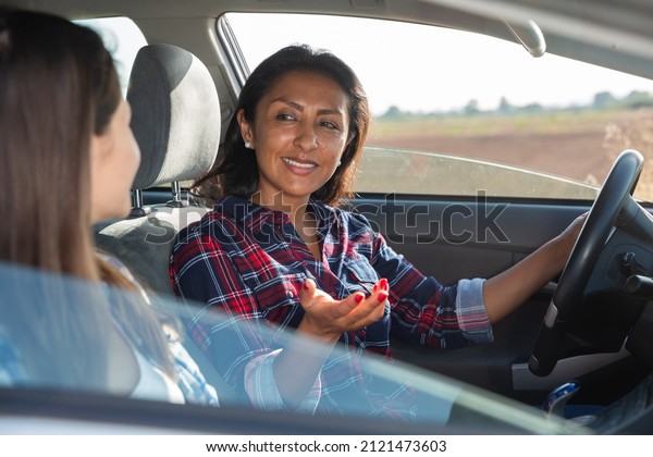 Portrait of\
happy female driver and her friend in\
car
