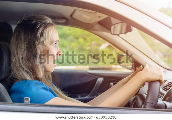 Portrait of happy\
female driver steering\
car