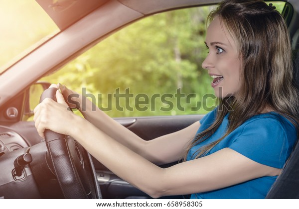 Portrait of happy\
female driver steering\
car