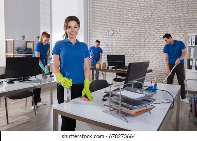 Portrait Of A Happy Female Janitor With Cleaning Equipments In Office