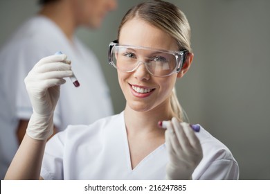 Portrait Of Happy Female Lab Technician Analyzing Blood Samples In Test Tube