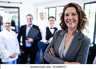 Portrait Of Happy Female Manager Standing With Arms Crossed In Restaurant