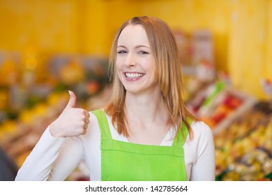 Portrait of happy female worker showing thumbsup gesture in grocery store - Powered by Shutterstock