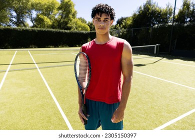 Portrait of happy fit biracial man holding tennis racket on sunny outdoor tennis court. Summer, healthy lifestyle, sport, hobbies and vacations. - Powered by Shutterstock