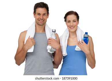 Portrait of a happy fit young couple with water bottles over white background
