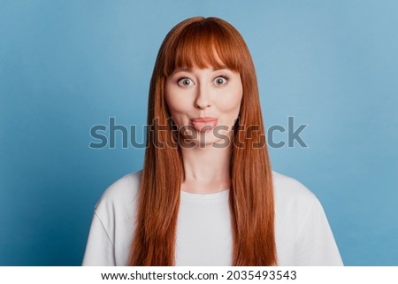 Portrait of happy foolish girl with tongue out isolated on blue background