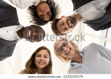 Portrait of happy friendly multi-ethnic team business people faces looking at camera, smiling diverse workers employees group gather in circle together, unity teambuilding concept, below bottom view