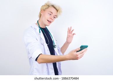 Portrait Of Happy Friendly Young Handsome Caucasian Doctor Man Taking Selfie And Waving Hand, Communicating On Video Call, Online Chatting.