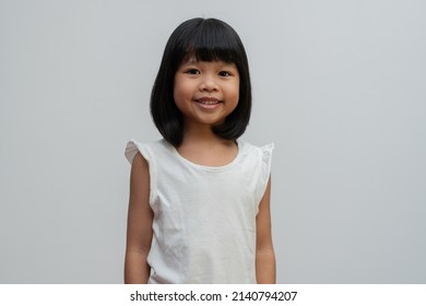 Portrait Of Happy And Funny Asian Child Girl On White Background, A Child Looking At Camera. Preschool Kid Dreaming Fill With Energy Feeling Healthy And Good Concept