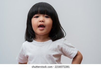 Portrait Of Happy And Funny Asian Child Girl On White Background, A Child Looking At Camera Hand Gesture. Preschool Kid Dreaming Fill With Energy Feeling Healthy And Good Concept