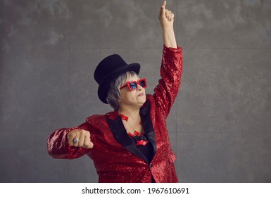 Portrait Of Happy Funny Senior Woman In Retro Style Outfit Feeling Free And Having Fun On Gray Background. Crazy Drunk Grandma And Mother-in-law Acting As Dancing Party Queen And DJ At Family Holiday