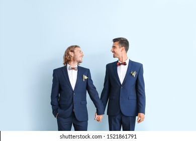 Portrait Of Happy Gay Couple On Their Wedding Day Against Color Background