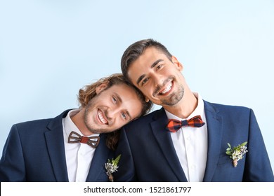 Portrait Of Happy Gay Couple On Their Wedding Day Against Color Background