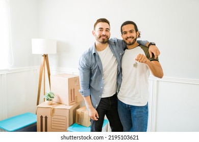 Portrait of a happy gay man and his boyfriend showing their new keys after buying a new house and moving in together - Shutterstock ID 2195103621